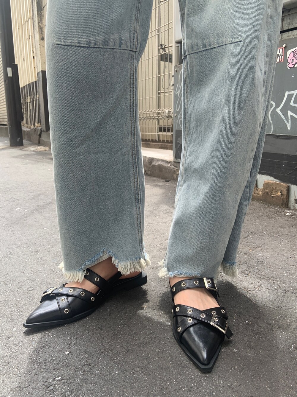 ブラック系のニット/セーター、ブルー系のデニムパンツ、ブラック系のパンプスを着用したレディースの夏コーディネートの5枚目の写真