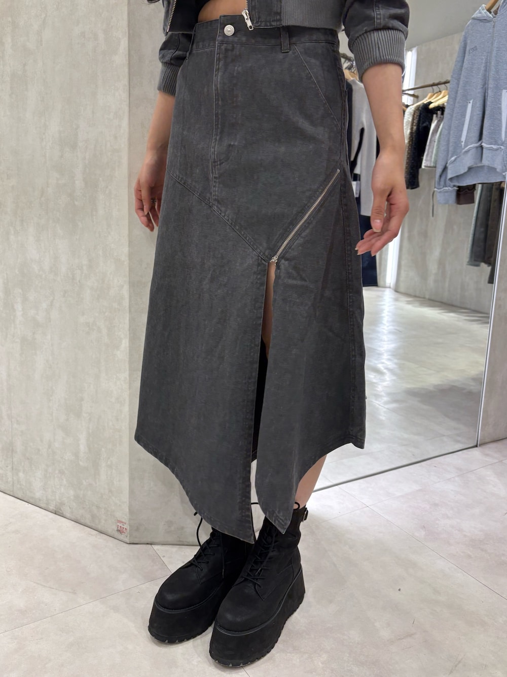 グレー系のブルゾン、ブラック系のキャミソール、グレー系のスカートを着用したレディースの春コーディネートの5枚目の写真