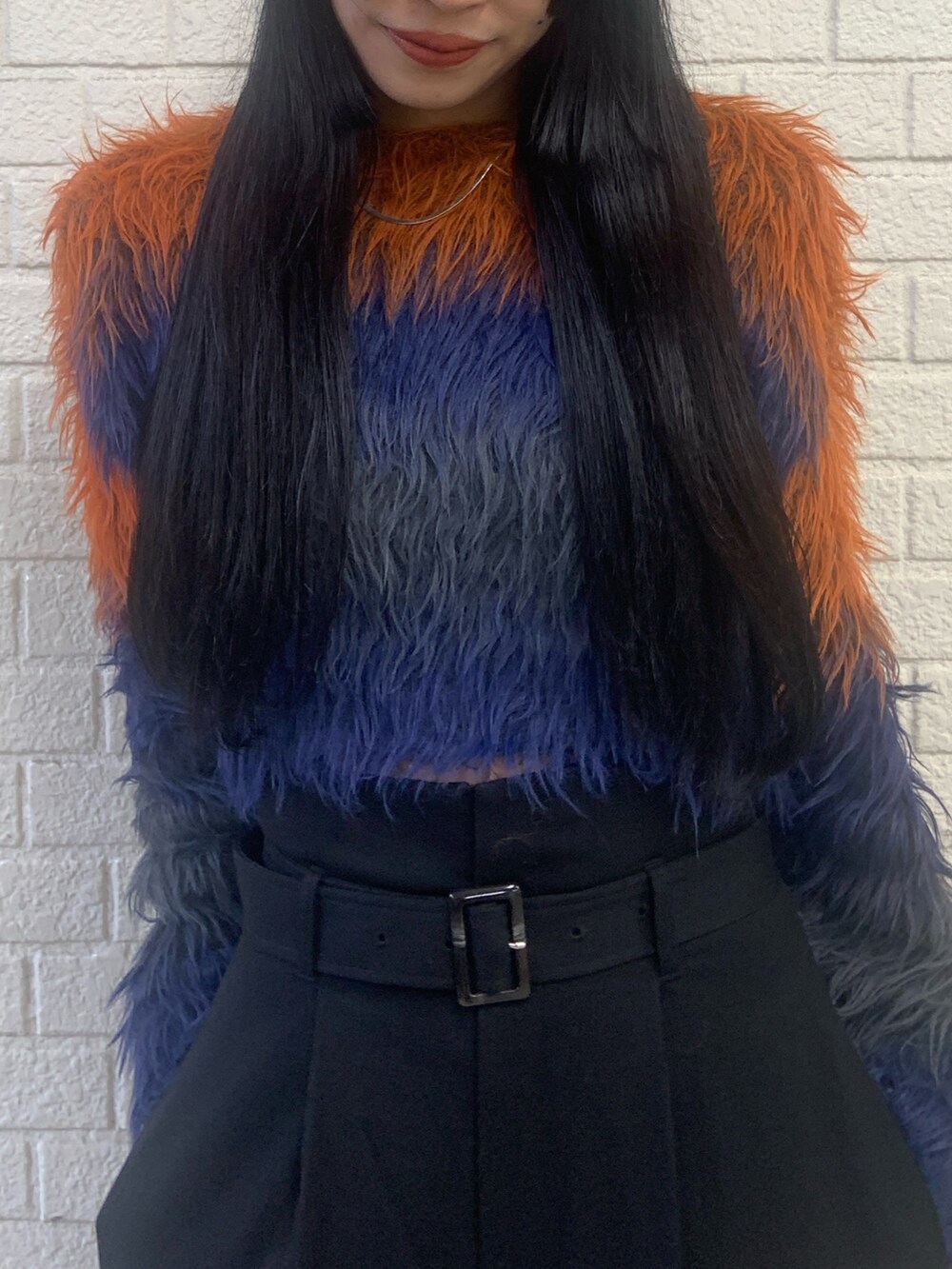 オレンジ系のニット/セーター、ブラック系のその他パンツ、ブラック系のブーツを着用したレディースの秋コーディネートの5枚目の写真