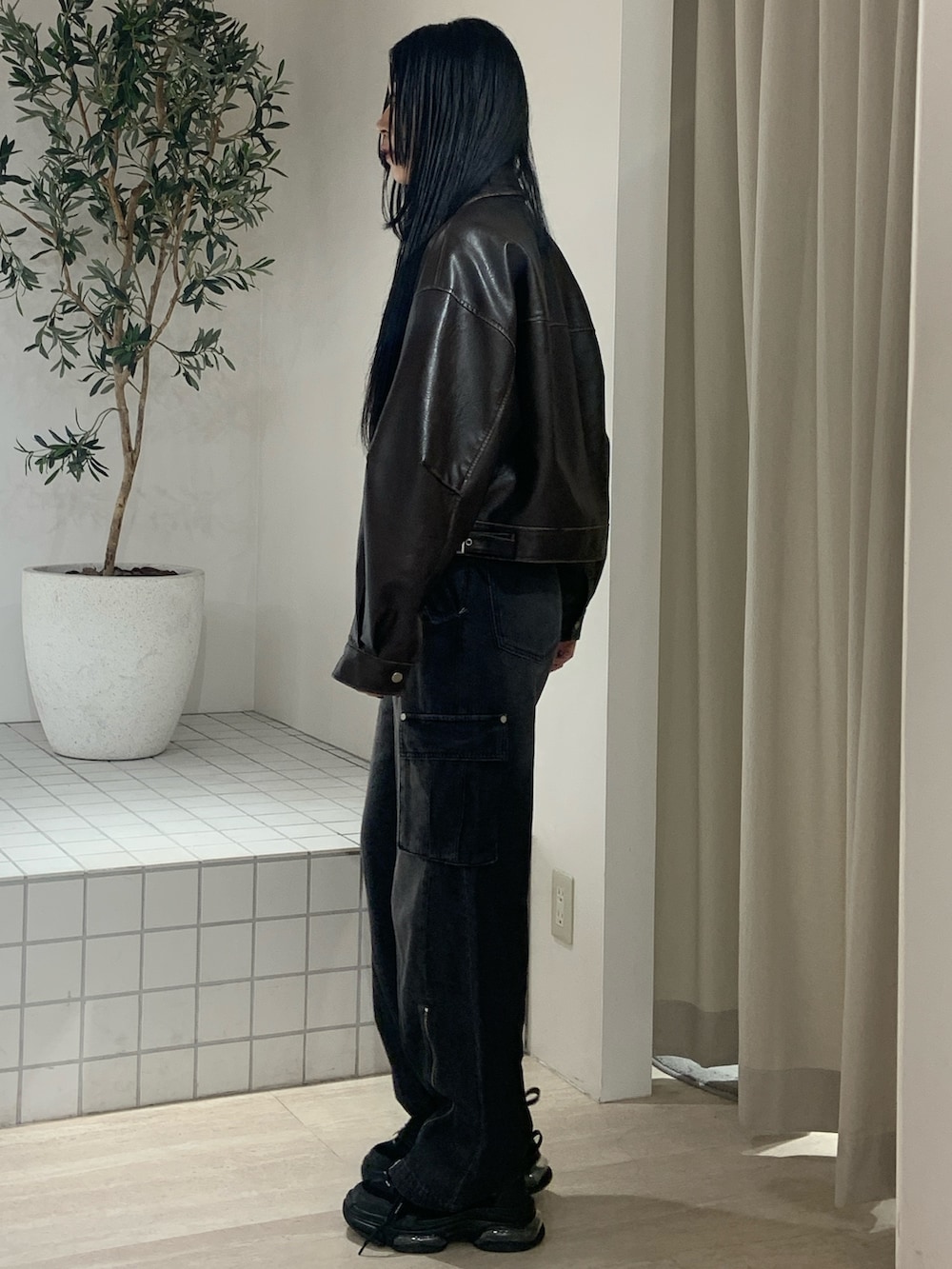 ブラウン系のブルゾン、ブルー系のタンクトップ、ブラック系のデニムパンツを着用したレディースの春コーディネートの3枚目の写真