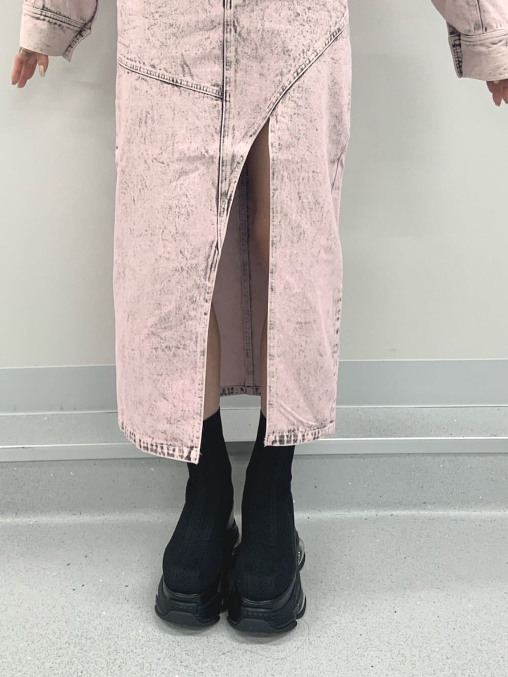 ブラック系のブーツ、ブラック系のニット/セーター、ピンク系のデニムスカートを着用したレディースの春コーディネートの6枚目の写真