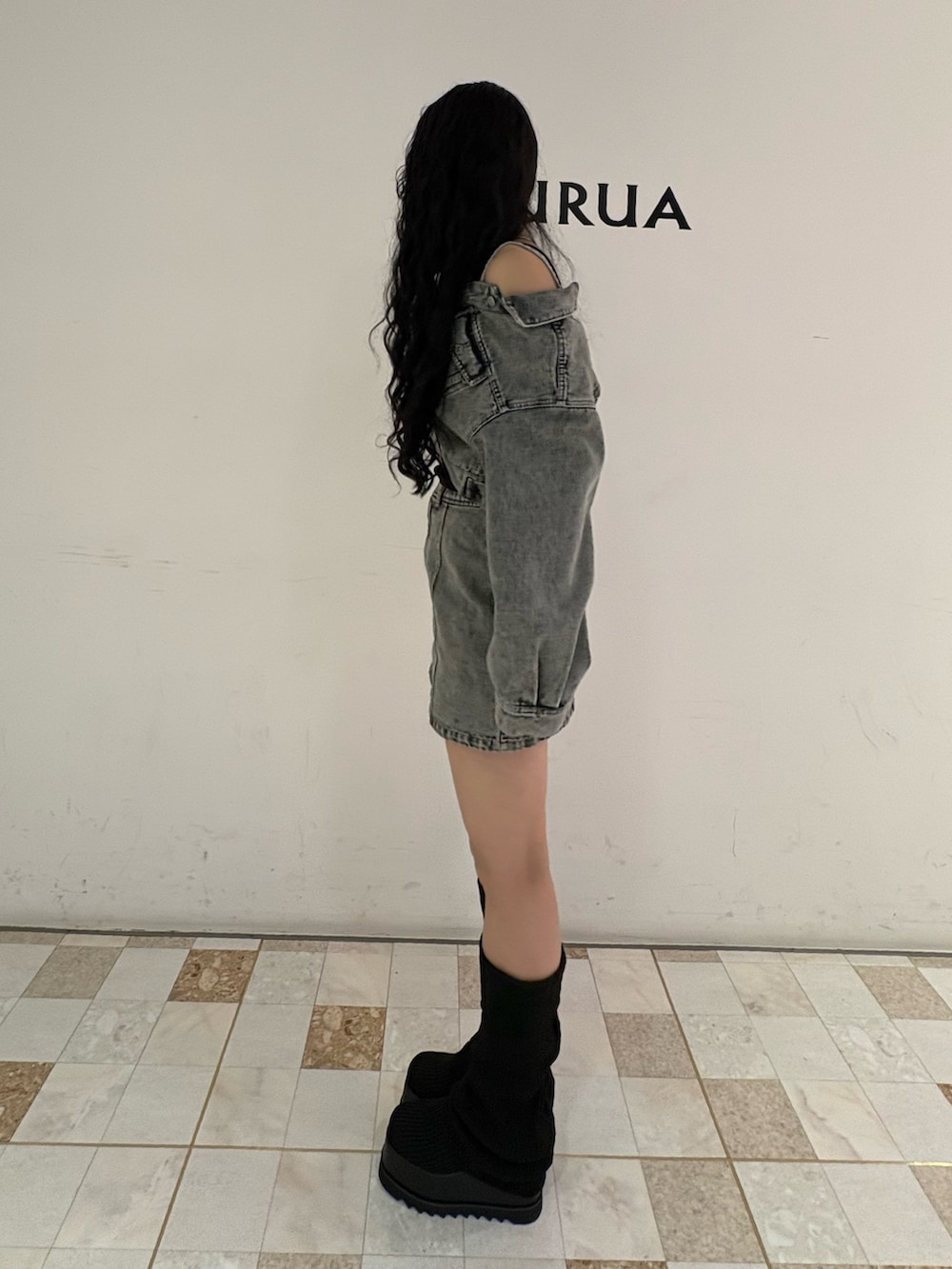 グリーン系のデニムジャケット、グリーン系のデニムスカート、ブラック系のブーツを着用したレディースの冬コーディネートの2枚目の写真