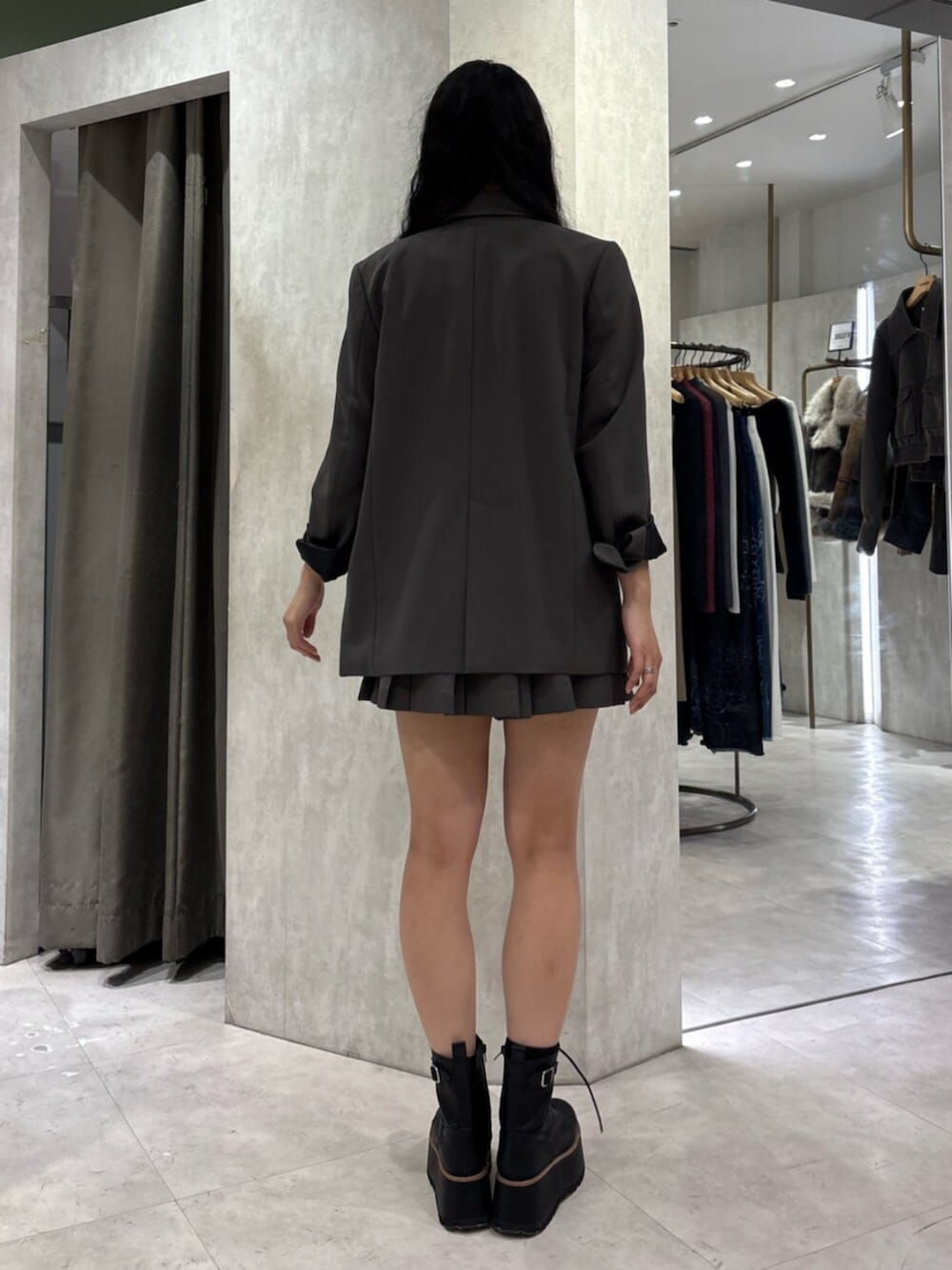 ブラック系のブーツ、グレー系のテーラードジャケット、グレー系のスカートを着用したレディースの冬コーディネートの4枚目の写真