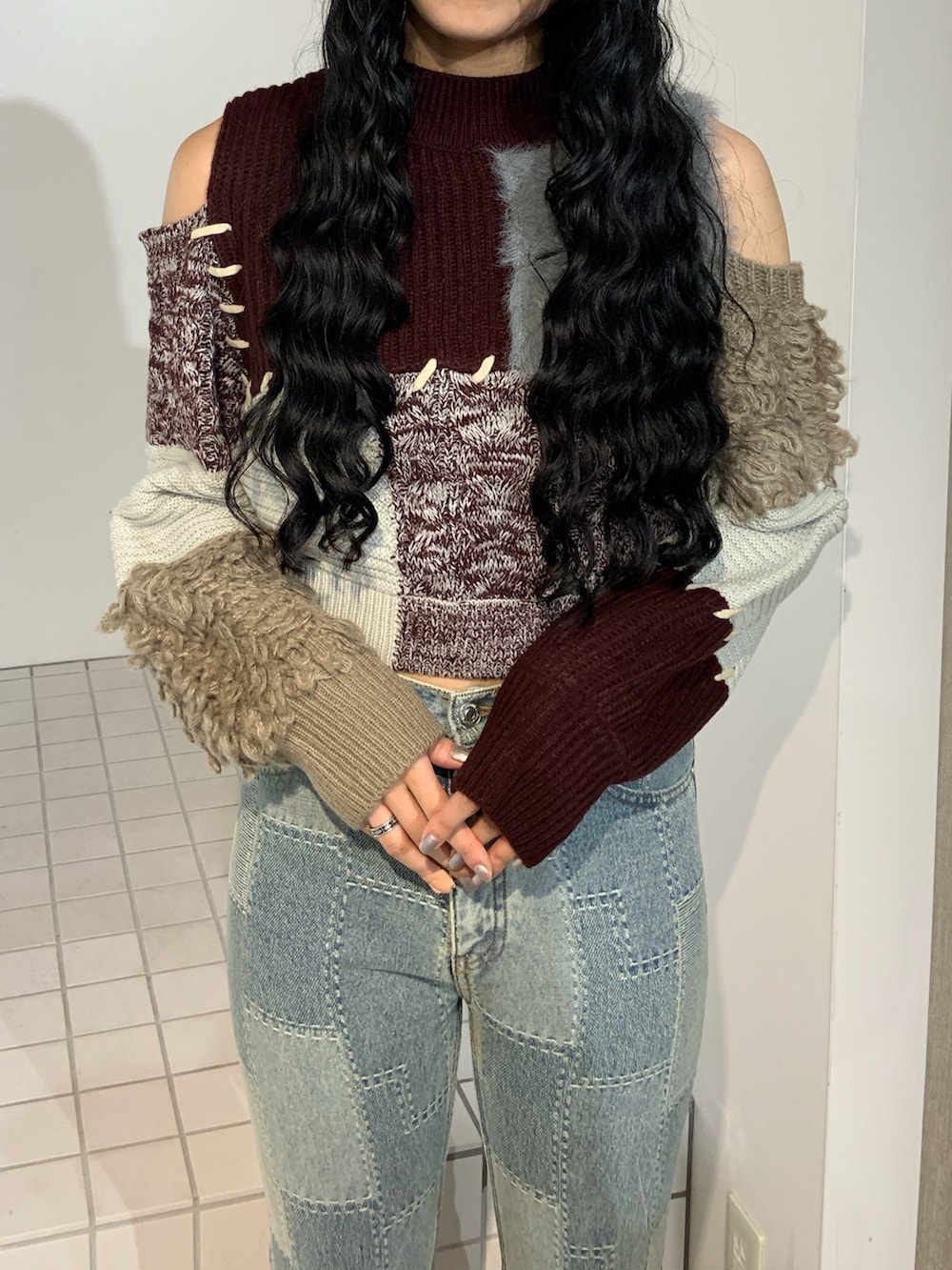 ブルー系のデニムパンツ、レッド系のニット/セーターを着用したレディースの秋コーディネートの4枚目の写真