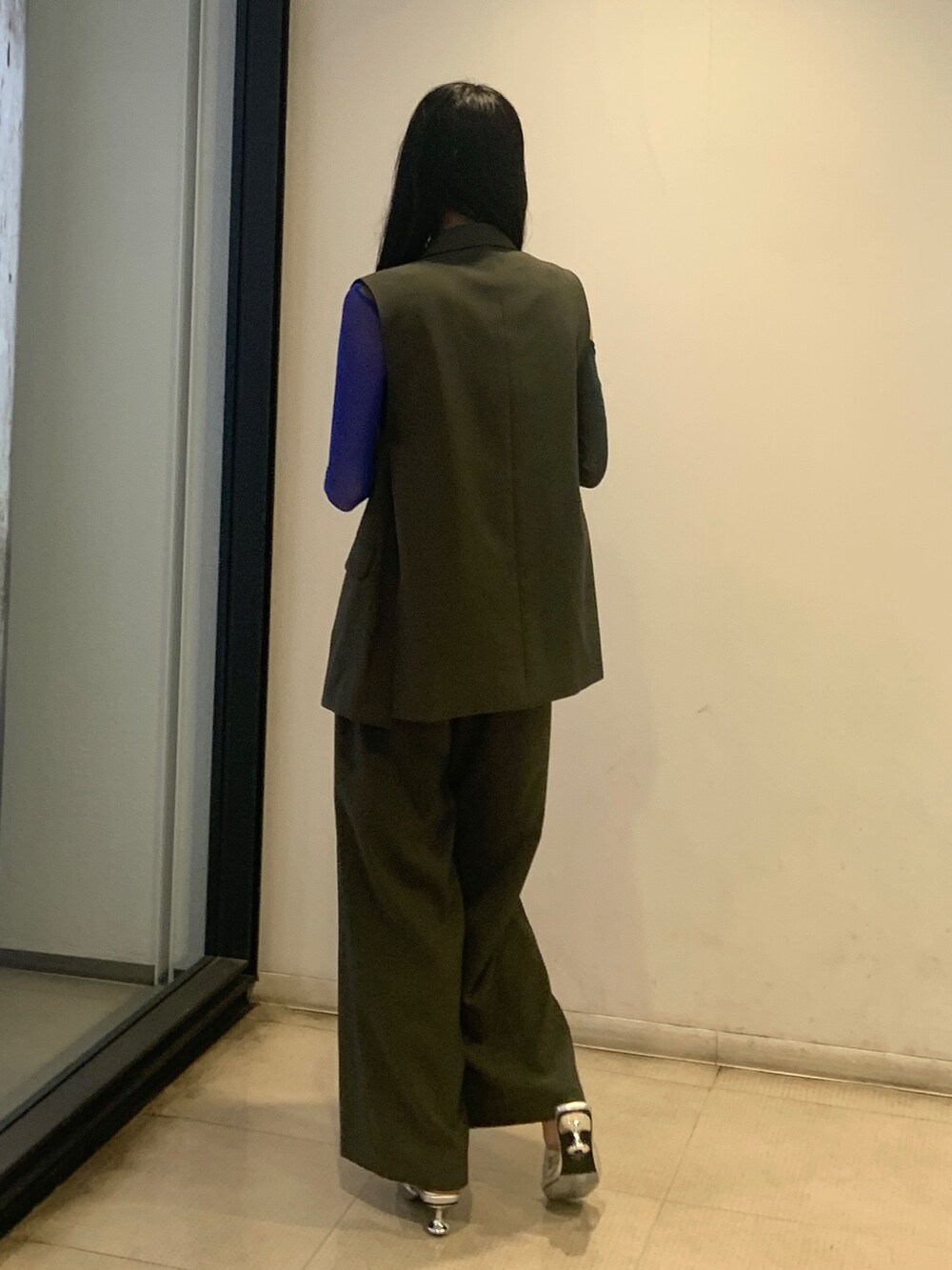 グリーン系のTシャツ/カットソー、グレー系のベスト、グレー系のその他パンツを着用したレディースの春コーディネートの4枚目の写真