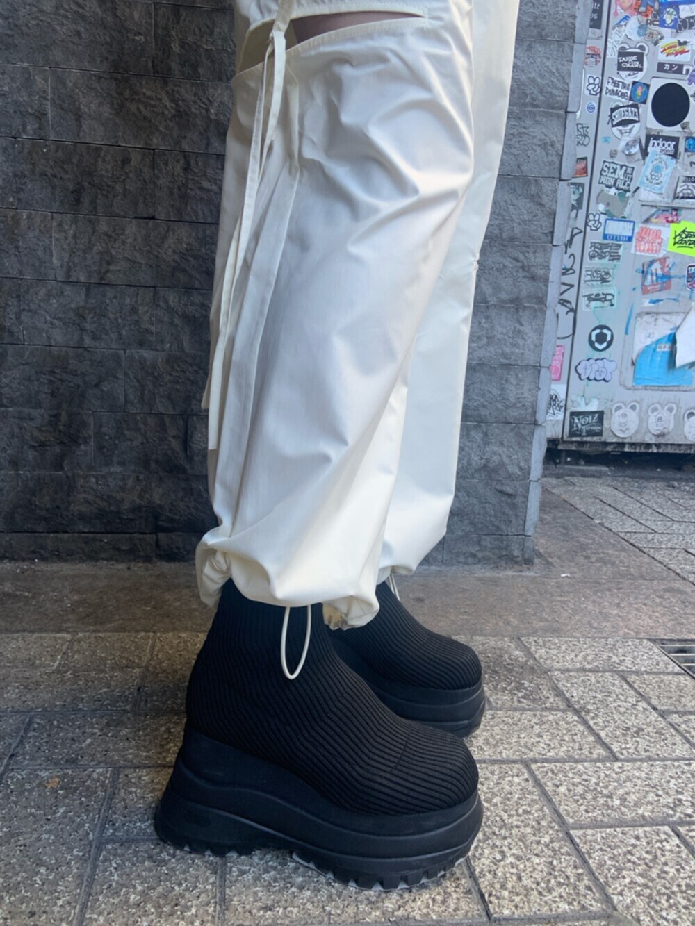 ブラック系のニット/セーター、ホワイト系のその他パンツ、ブラック系のブーツを着用したレディースの冬コーディネートの7枚目の写真