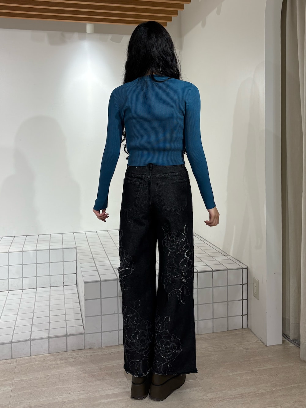 ブルー系のニット/セーター、ブラック系のデニムパンツを着用したレディースの冬コーディネートの3枚目の写真