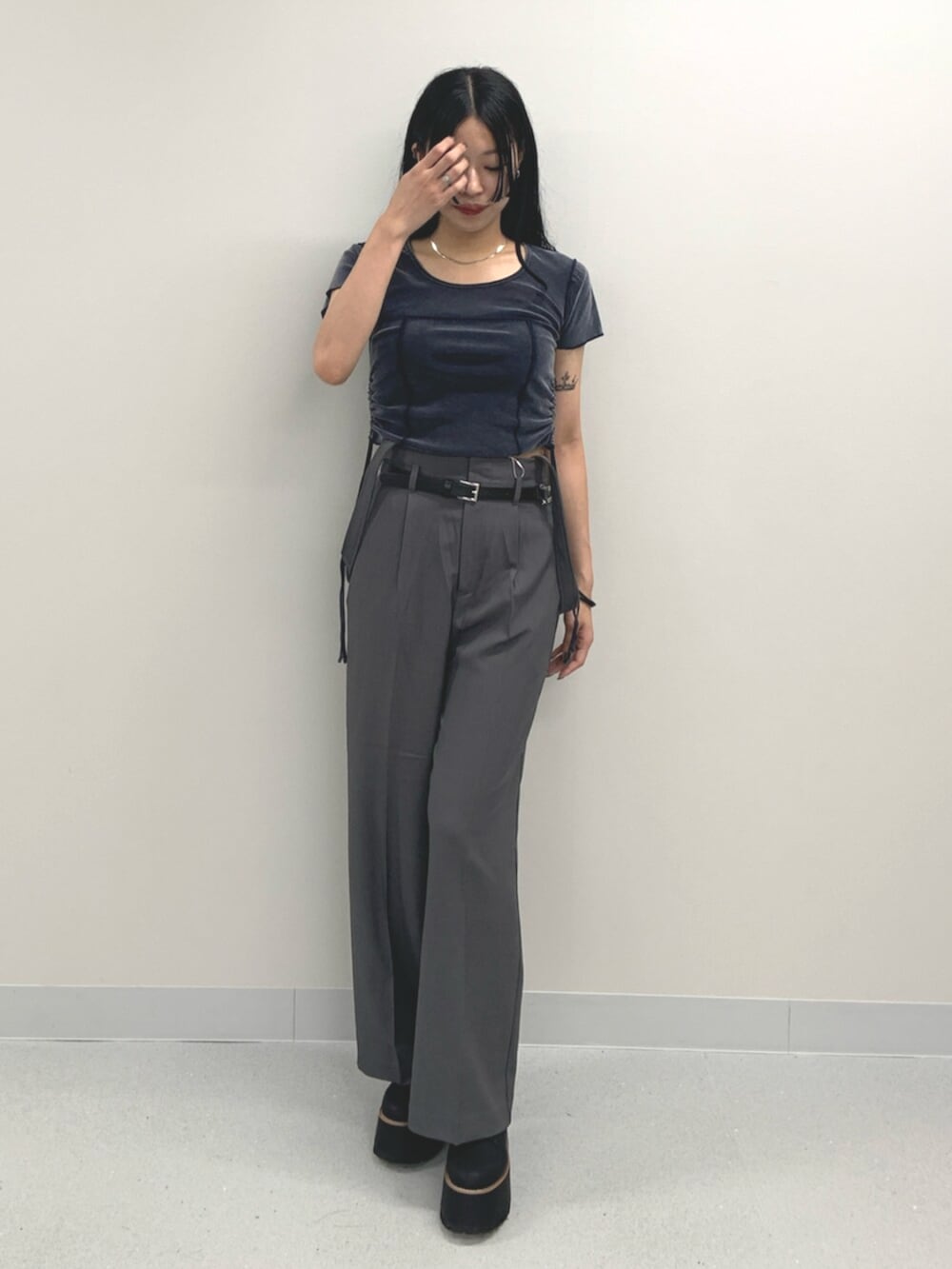 ブルー系のTシャツ/カットソー、ブラック系のブーツ、グレー系のスラックスを着用したレディースの夏コーディネートの2枚目の写真