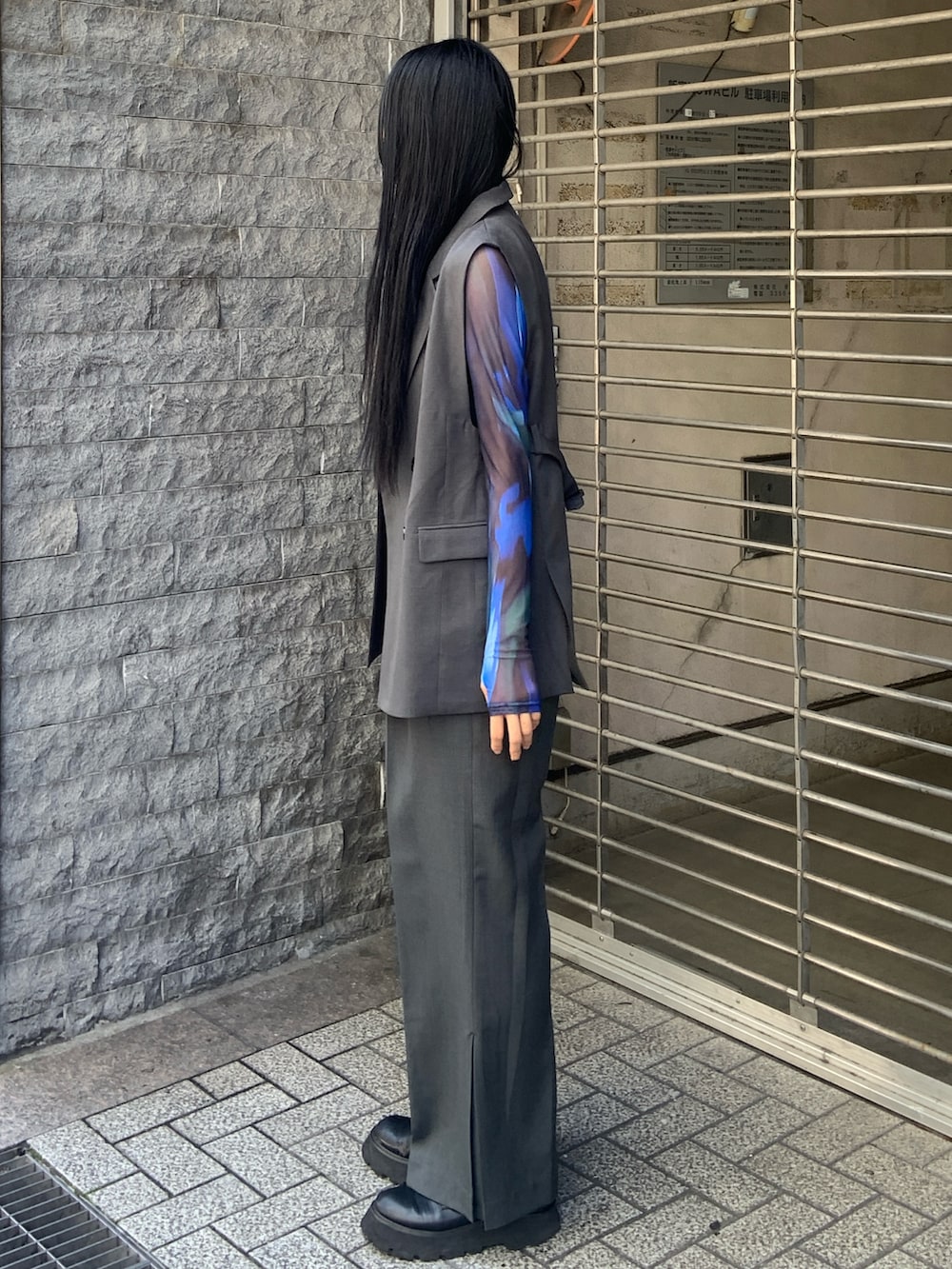 グレー系のベスト、グレー系のその他パンツ、グリーン系のTシャツ/カットソーを着用したレディースの春コーディネートの2枚目の写真