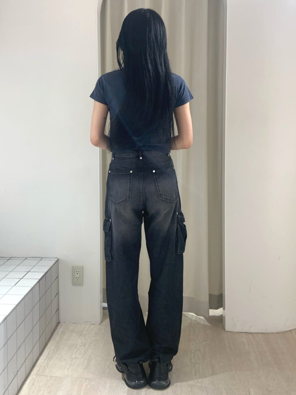 ブルー系のTシャツ/カットソー、ブラック系のデニムパンツ、ブラック系のスニーカーを着用したレディースの春コーディネートの4枚目の写真