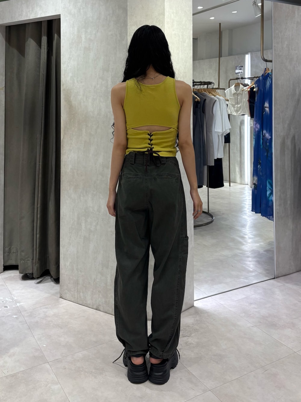 イエロー系のタンクトップ、グリーン系のその他パンツ、ブラック系のサンダルを着用したレディースの夏コーディネートの3枚目の写真