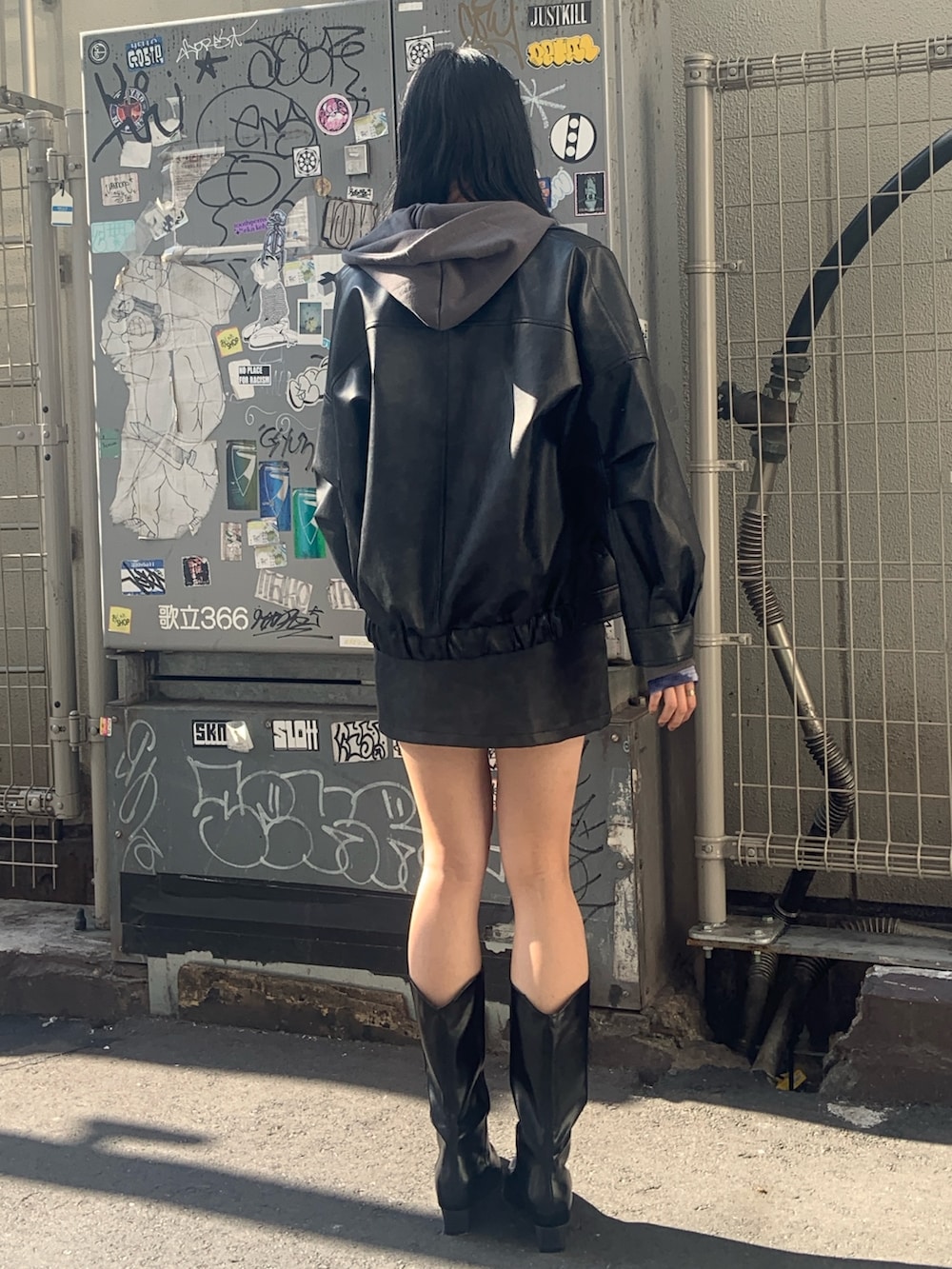 ブラック系のブルゾン、ブラック系のスカート、グレー系のパーカーを着用したレディースの冬コーディネートの4枚目の写真