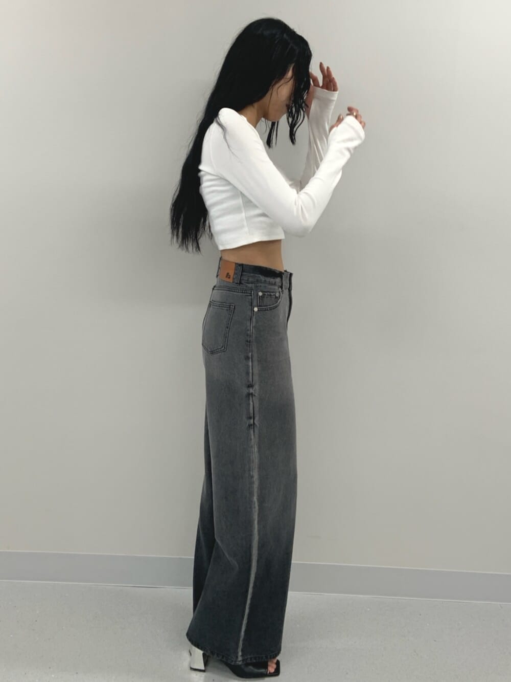 ホワイト系のTシャツ/カットソー、ブラック系のブーツ、ブラック系のデニムパンツを着用したレディースの春コーディネートの2枚目の写真