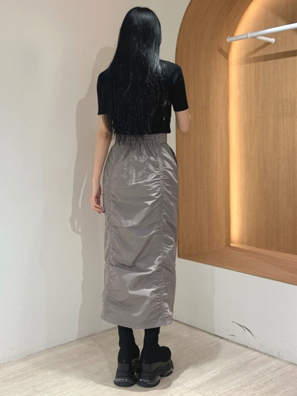 ブラック系のブーツ、ブラック系のニット/セーター、グレー系のスカートを着用したレディースの春コーディネートの4枚目の写真