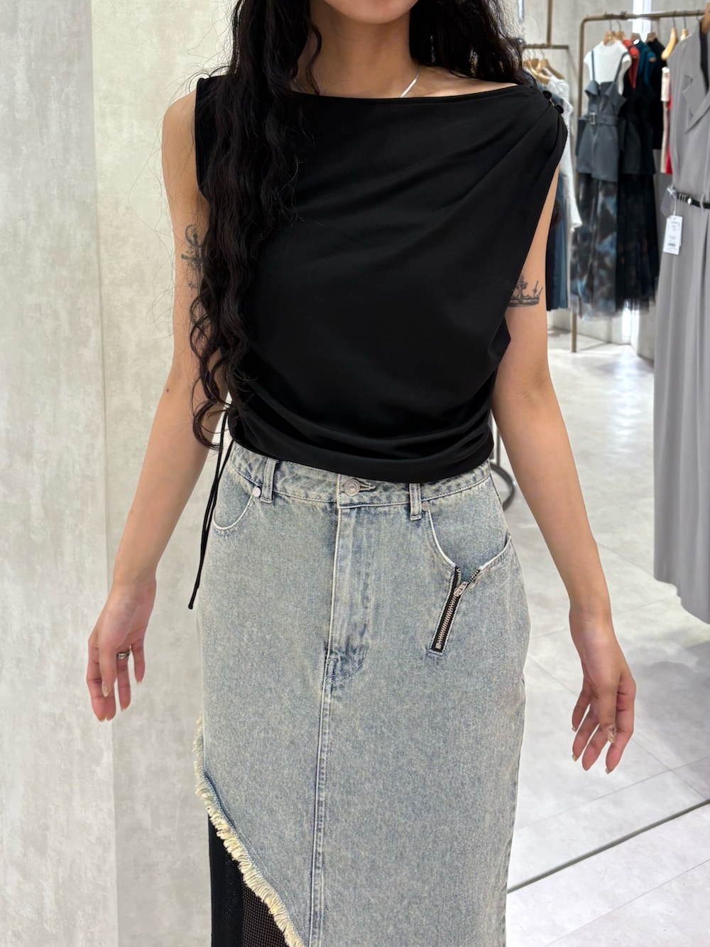 ブラック系のTシャツ/カットソー、ブルー系のデニムスカート、ブラック系のサンダルを着用したレディースの夏コーディネートの4枚目の写真