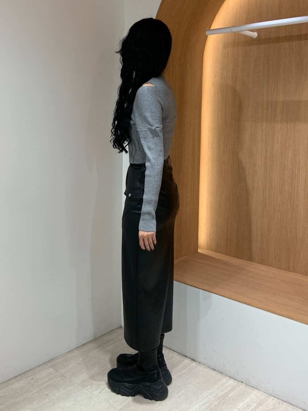 グレー系のニット/セーター、ブラック系のスカートを着用したレディースの秋コーディネートの3枚目の写真