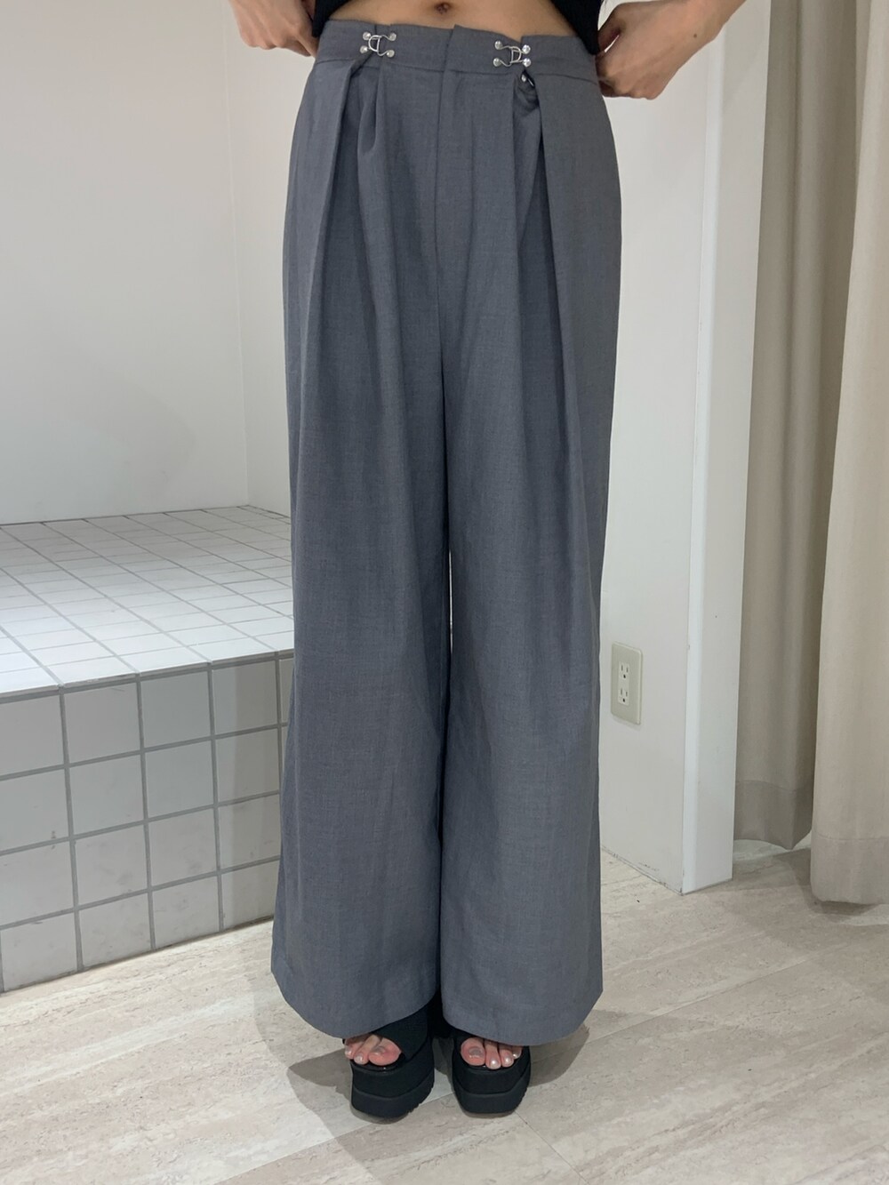 ブラック系のニット/セーター、グレー系のその他パンツ、ブラック系のサンダルを着用したレディースの夏コーディネートの5枚目の写真