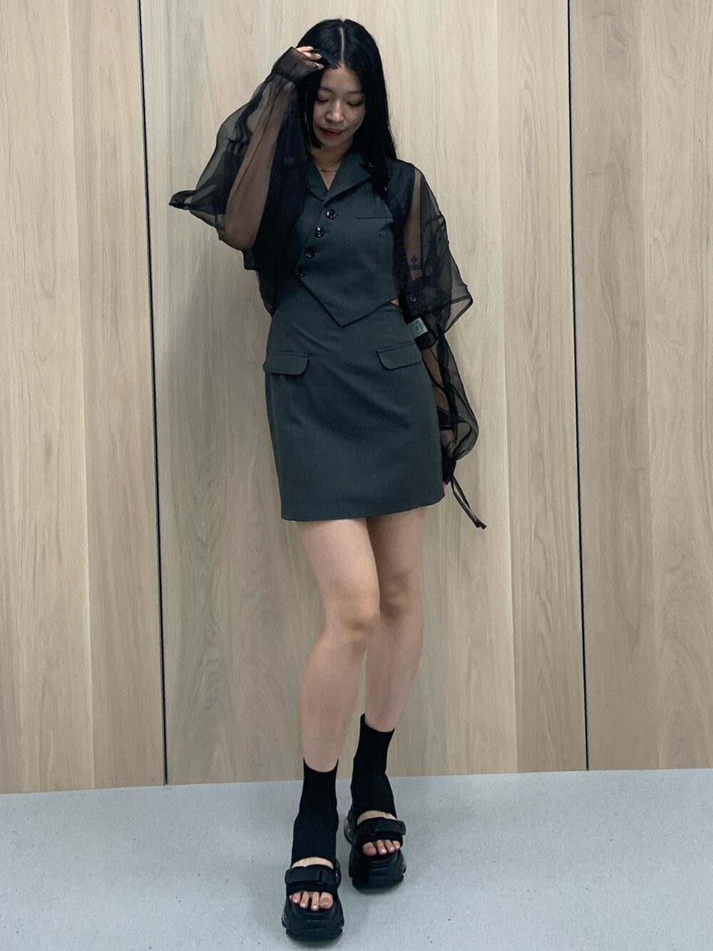 グレー系のワンピース、ブラック系のシャツ/ブラウス、ブラック系のサンダルを着用したレディースの春コーディネートの2枚目の写真