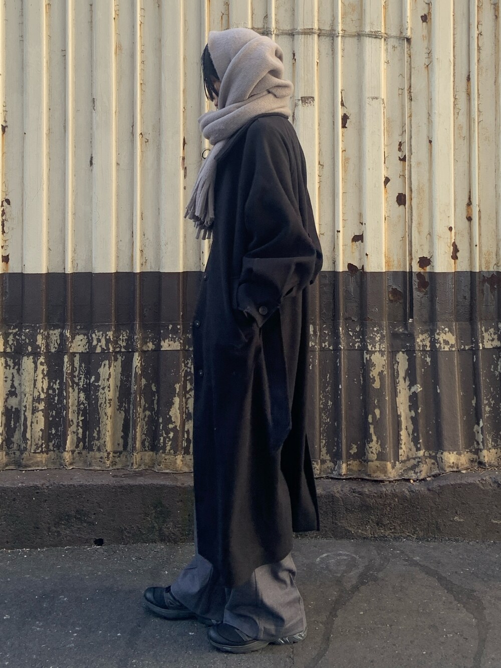 ブラック系のその他アウター、グレー系のその他パンツ、グレー系のマフラーを着用したレディースの冬コーディネートの3枚目の写真