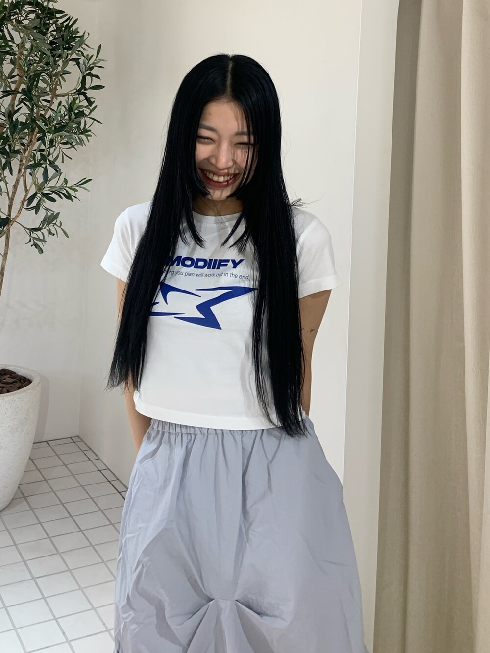 ホワイト系のTシャツ/カットソー、ブルー系のスカート、ブラック系のブーツを着用したレディースの春コーディネートの5枚目の写真