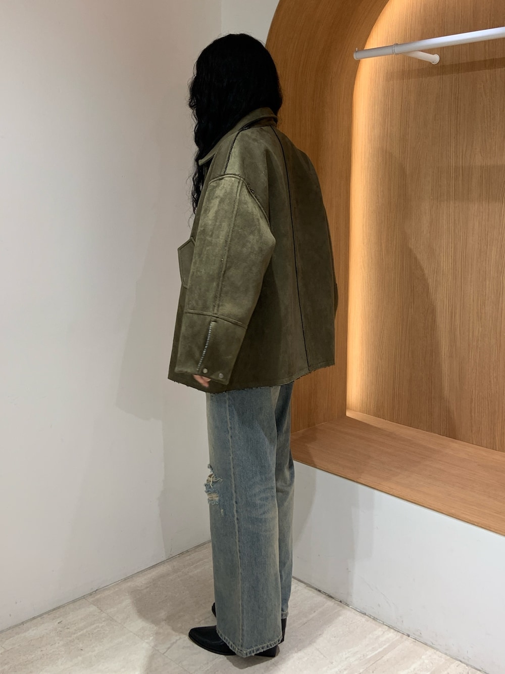 ブルー系のデニムパンツ、グリーン系のテーラードジャケットを着用したレディースの秋コーディネートの3枚目の写真