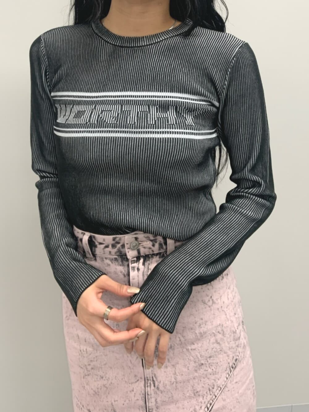 ブラック系のブーツ、ブラック系のニット/セーター、ピンク系のデニムスカートを着用したレディースの春コーディネートの5枚目の写真