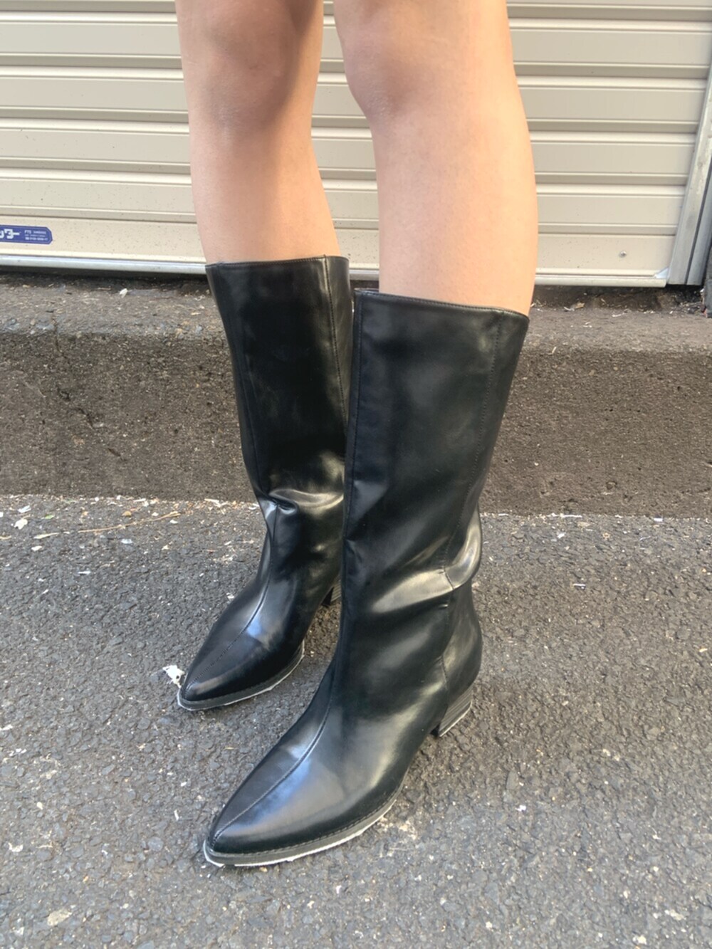 ブラック系のボストンバッグ、グレー系のワンピース、ブラック系のブーツを着用したレディースの冬コーディネートの7枚目の写真