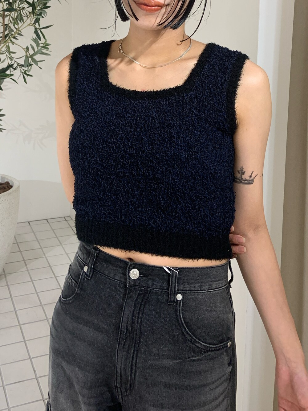 ブラック系のニット/セーター、ブラック系のデニムパンツ、ブラック系のサンダルを着用したレディースの夏コーディネートの5枚目の写真