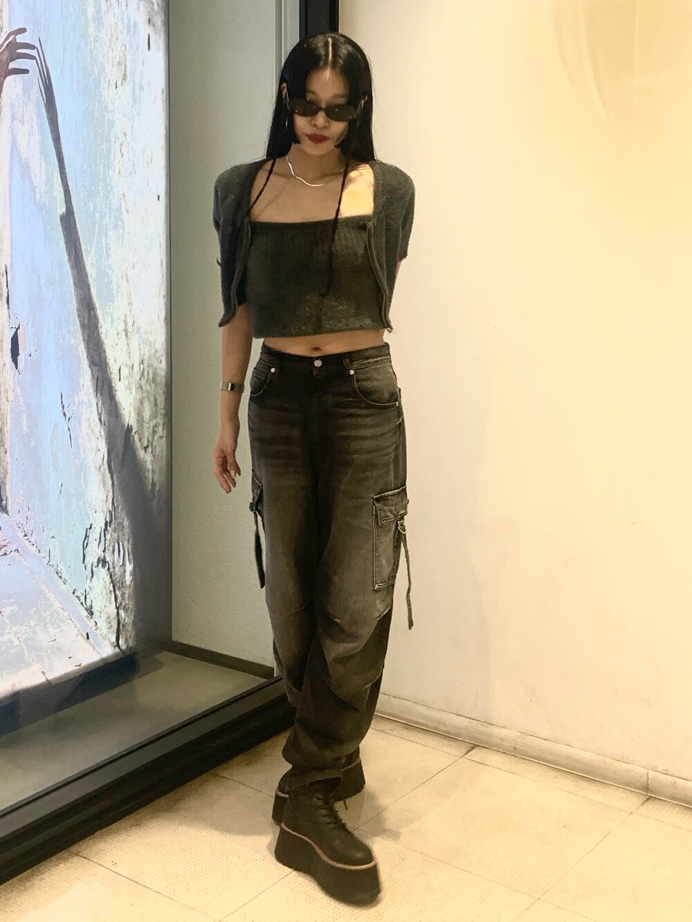 グレー系のニット/セーター、ブラック系のデニムパンツ、ブラック系のブーツを着用したレディースの秋コーディネートの4枚目の写真