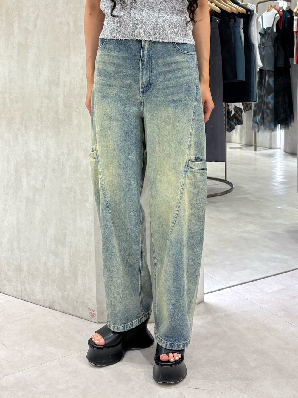グレー系のタンクトップ、ブルー系のデニムパンツ、ブラック系のサンダルを着用したレディースの夏コーディネートの5枚目の写真