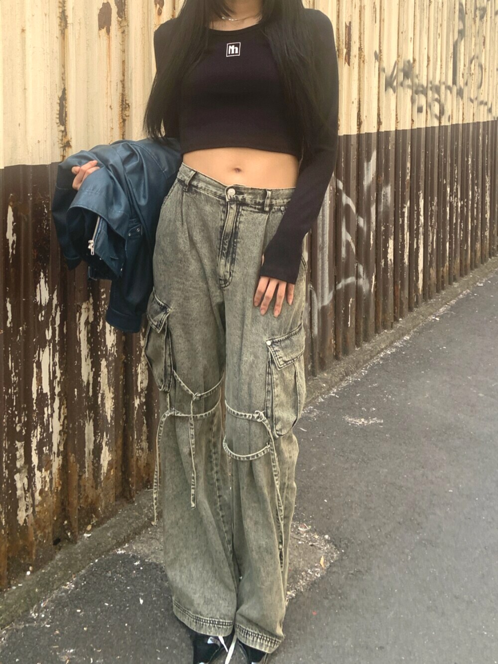 ブラック系のサンダル、ブラック系のTシャツ/カットソー、ブラック系のデニムパンツを着用したレディースの春コーディネートの5枚目の写真