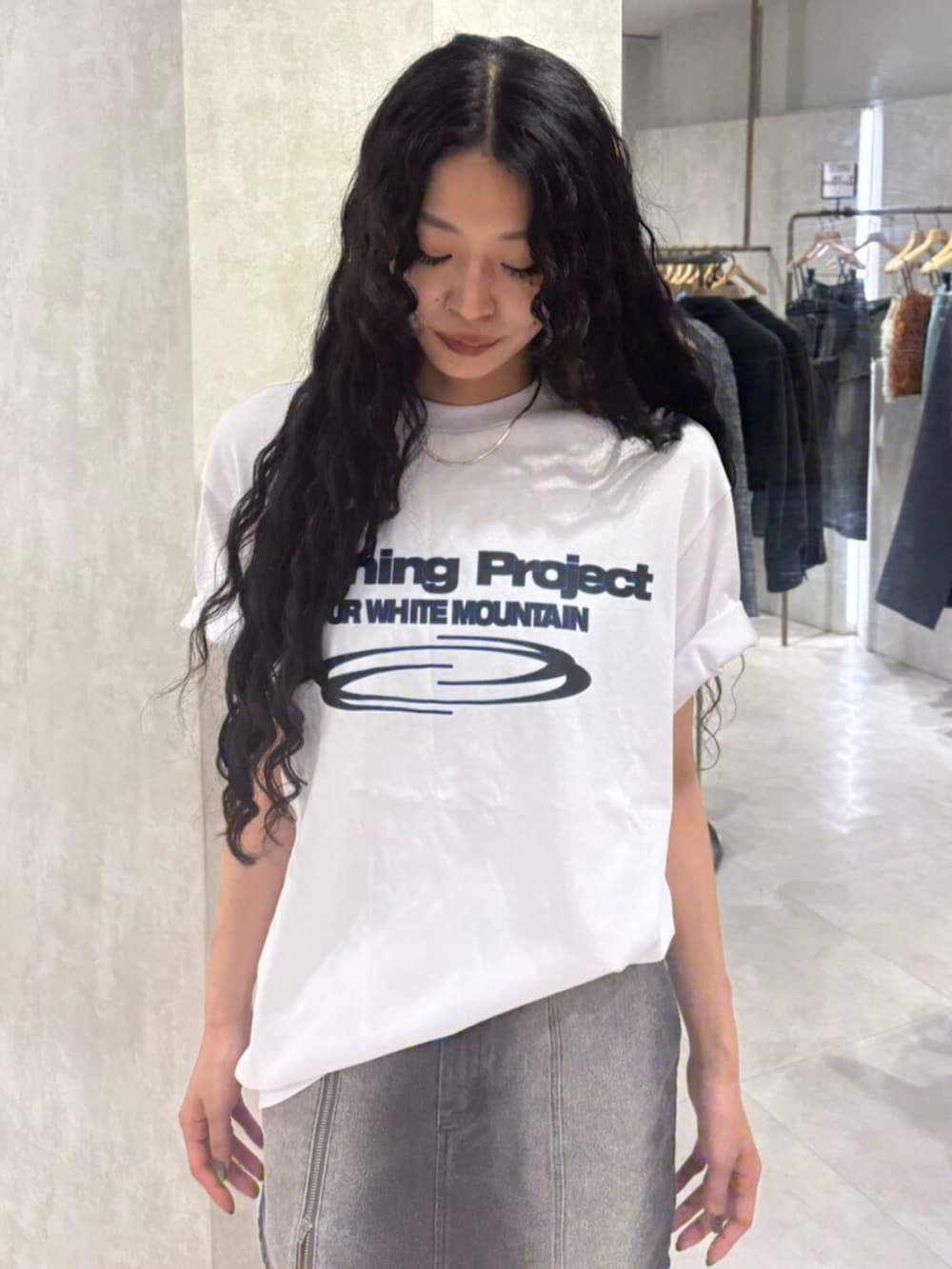 ブラック系のブーツ、ブラック系のデニムスカート、ホワイト系のTシャツ/カットソーを着用したレディースの春コーディネートの4枚目の写真