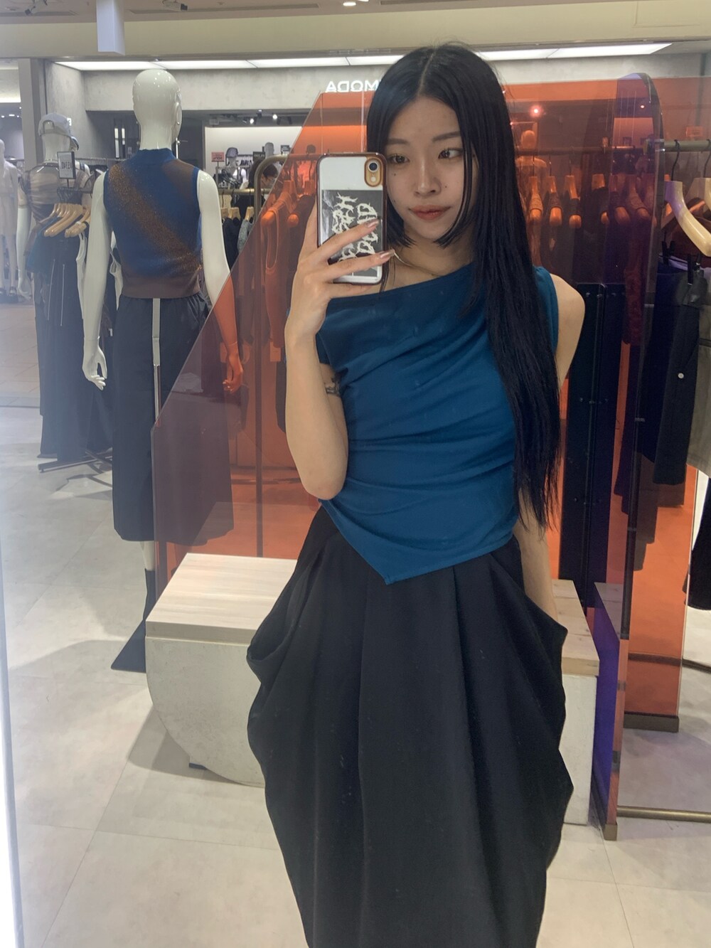 ブルー系のTシャツ/カットソー、ブラック系のスカートを着用したレディースの夏コーディネートの2枚目の写真