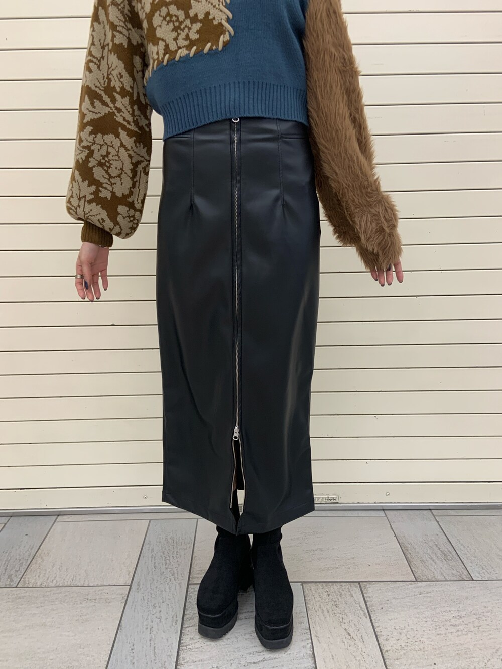 ブルー系のニット/セーター、ブラック系のスカート、ブラック系のブーツを着用したレディースの冬コーディネートの6枚目の写真
