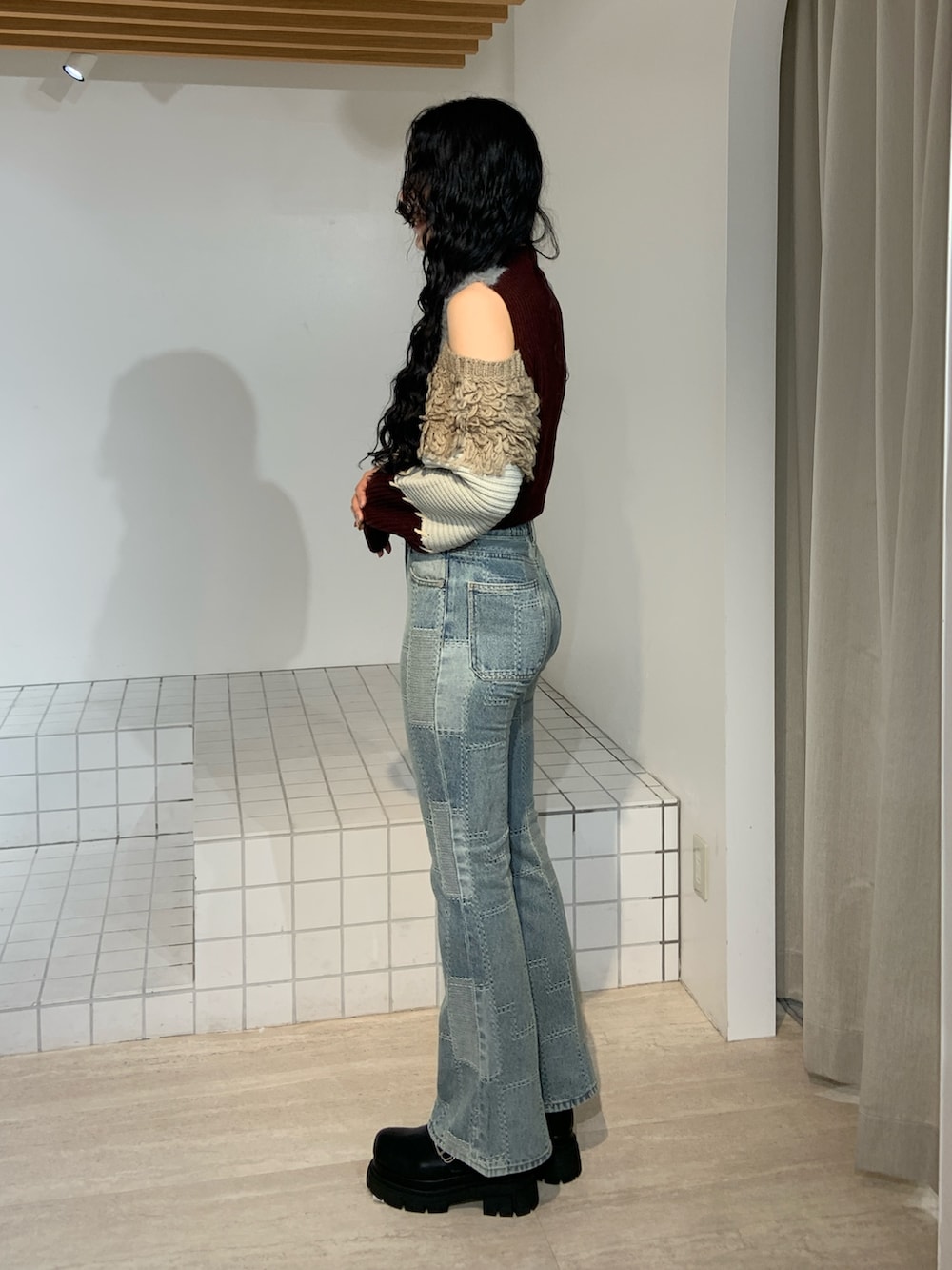 ブルー系のデニムパンツ、レッド系のニット/セーターを着用したレディースの秋コーディネートの2枚目の写真