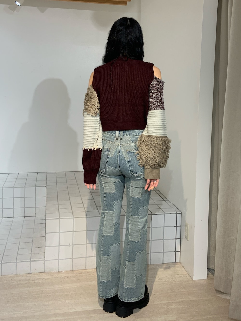 ブルー系のデニムパンツ、レッド系のニット/セーターを着用したレディースの秋コーディネートの3枚目の写真