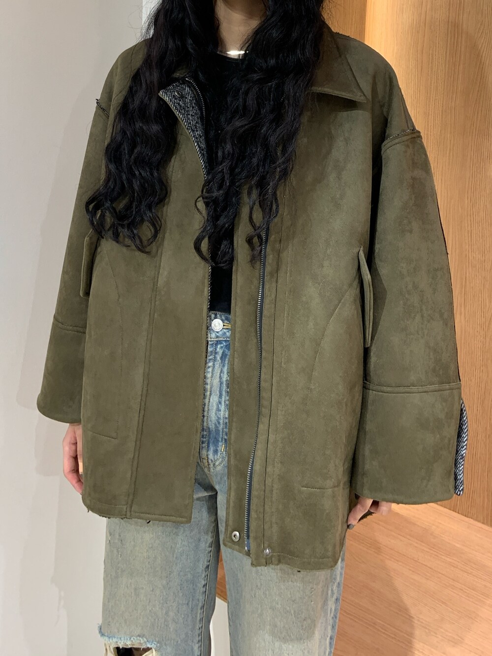 ブルー系のデニムパンツ、グリーン系のテーラードジャケットを着用したレディースの秋コーディネートの5枚目の写真