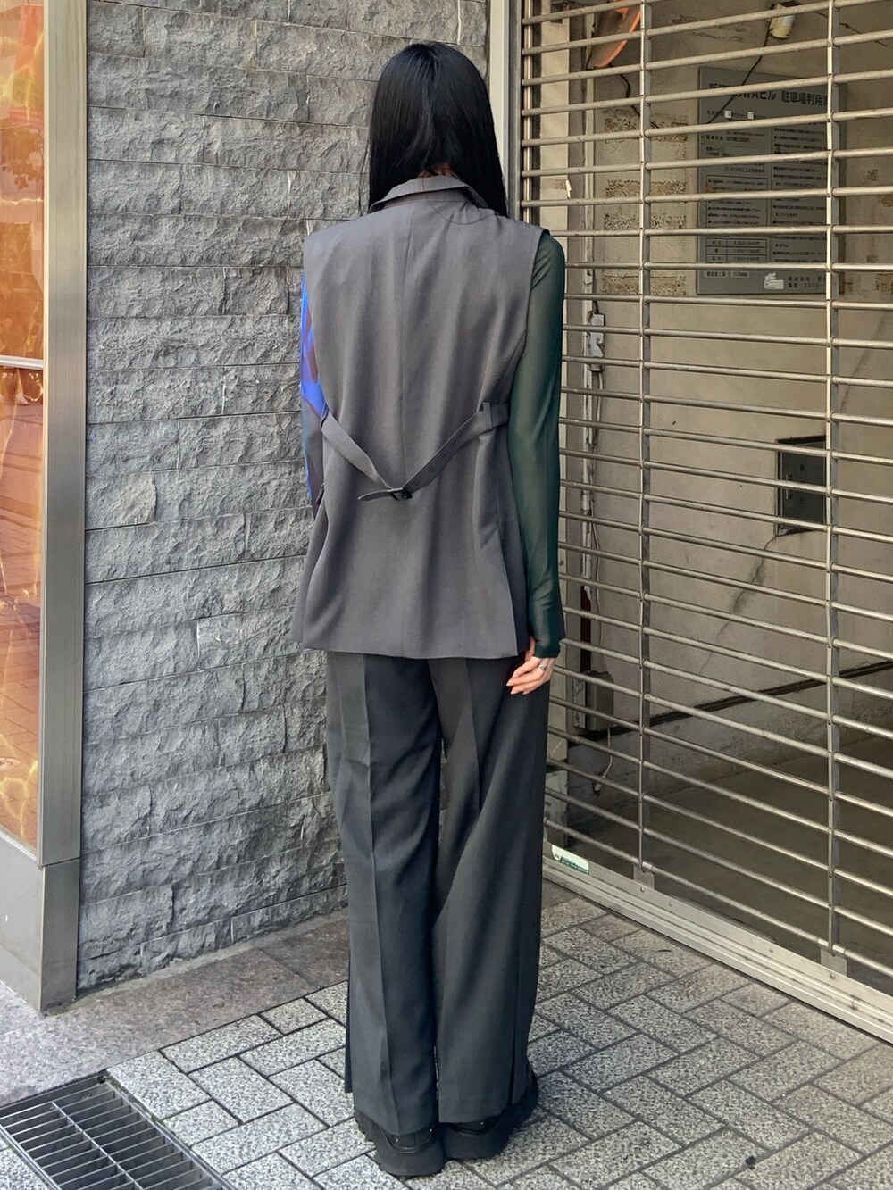 グレー系のベスト、グレー系のその他パンツ、グリーン系のTシャツ/カットソーを着用したレディースの春コーディネートの3枚目の写真