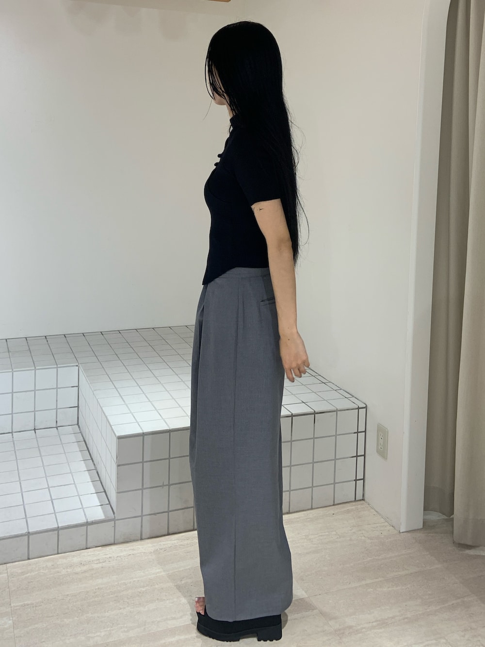 ブラック系のニット/セーター、グレー系のその他パンツ、ブラック系のサンダルを着用したレディースの夏コーディネートの2枚目の写真