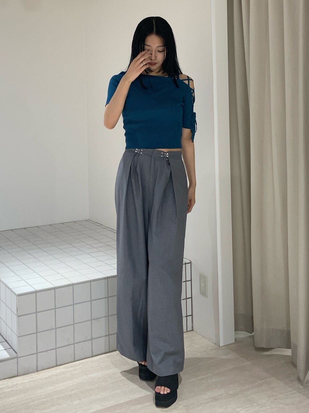 ブルー系のニット/セーター、グレー系のその他パンツ、ブラック系のサンダルを着用したレディースの夏コーディネートの2枚目の写真