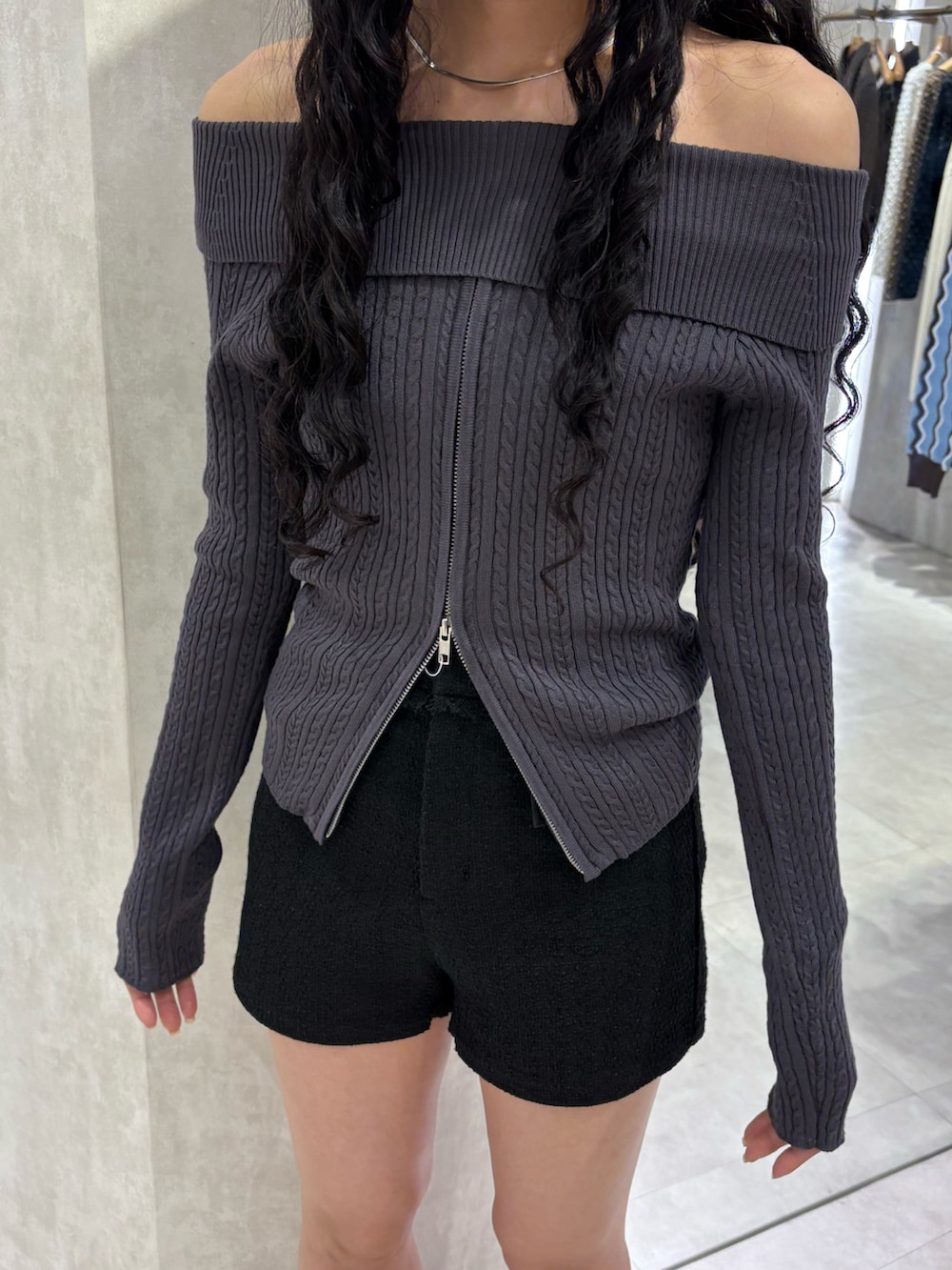 グレー系のニット/セーター、ブラック系のその他パンツ、ブラック系のブーツを着用したレディースの春コーディネートの4枚目の写真