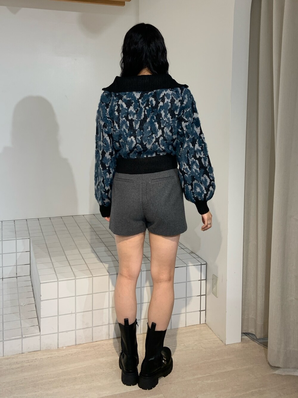 ブラック系のニット/セーター、グレー系のその他パンツ、ブラック系のブーツを着用したレディースの秋コーディネートの3枚目の写真