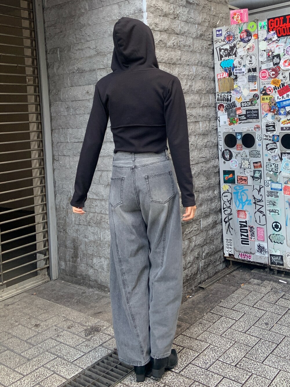 ブラック系のパーカー、ブラック系のデニムパンツ、ブラック系のブーツを着用したレディースの冬コーディネートの4枚目の写真