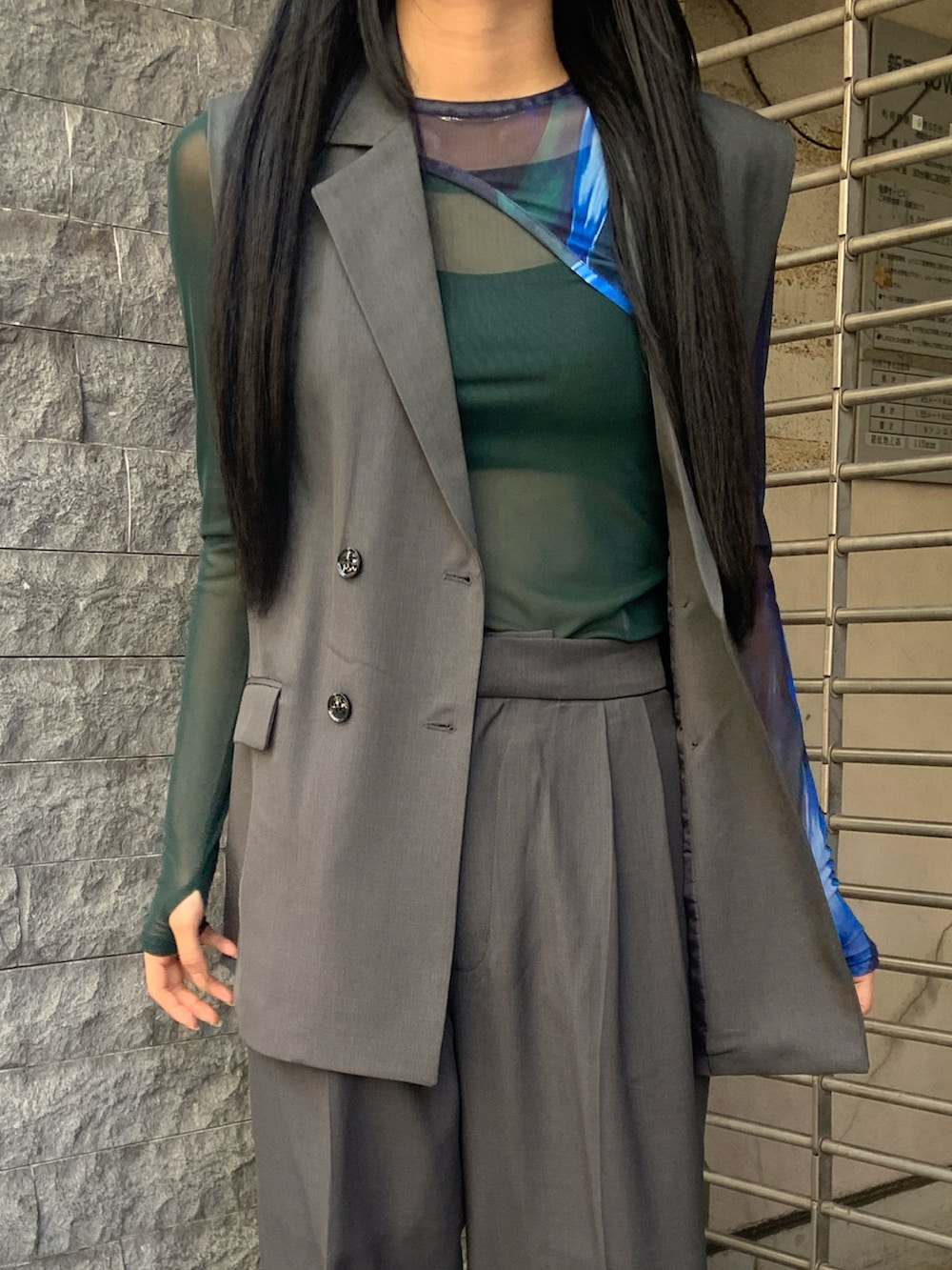 グレー系のベスト、グレー系のその他パンツ、グリーン系のTシャツ/カットソーを着用したレディースの春コーディネートの4枚目の写真