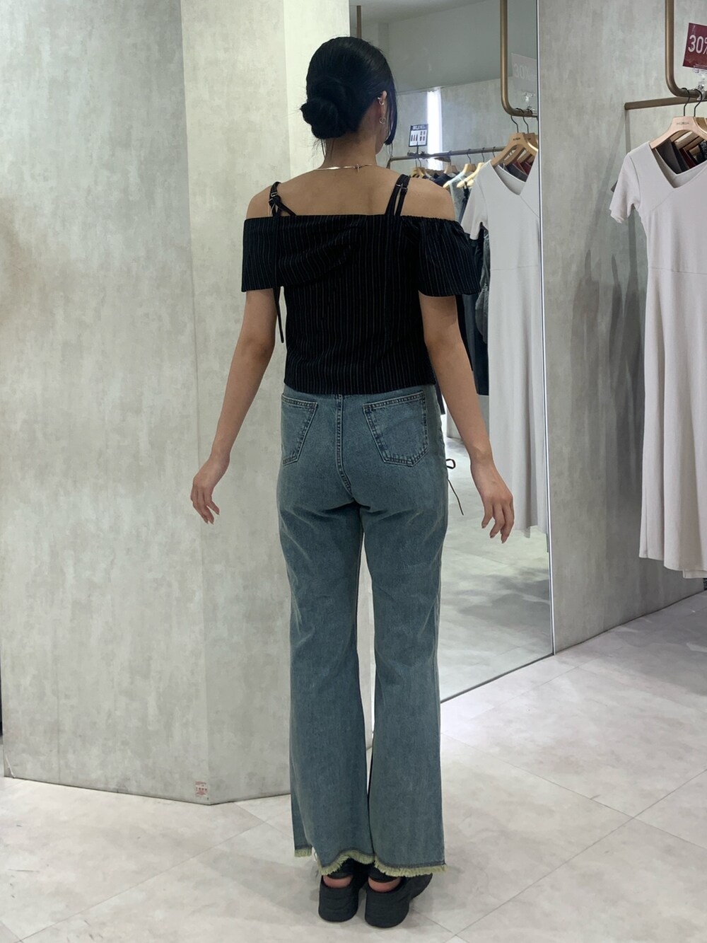 ブラック系のシャツ/ブラウス、ブルー系のデニムパンツを着用したレディースの夏コーディネートの3枚目の写真