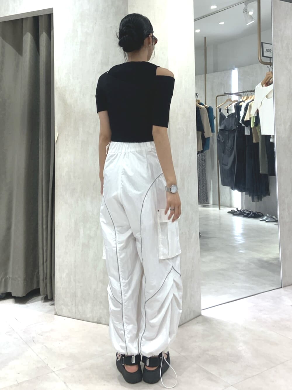 ブラック系のサンダル、ブラック系のニット/セーター、ホワイト系のカーゴパンツを着用したレディースの春コーディネートの4枚目の写真