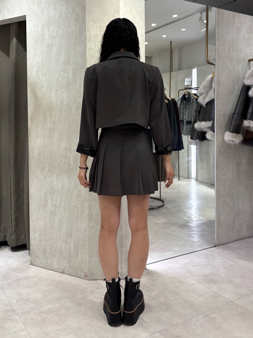 グレー系のテーラードジャケット、グレー系のスカートを着用したレディースの冬コーディネートの3枚目の写真