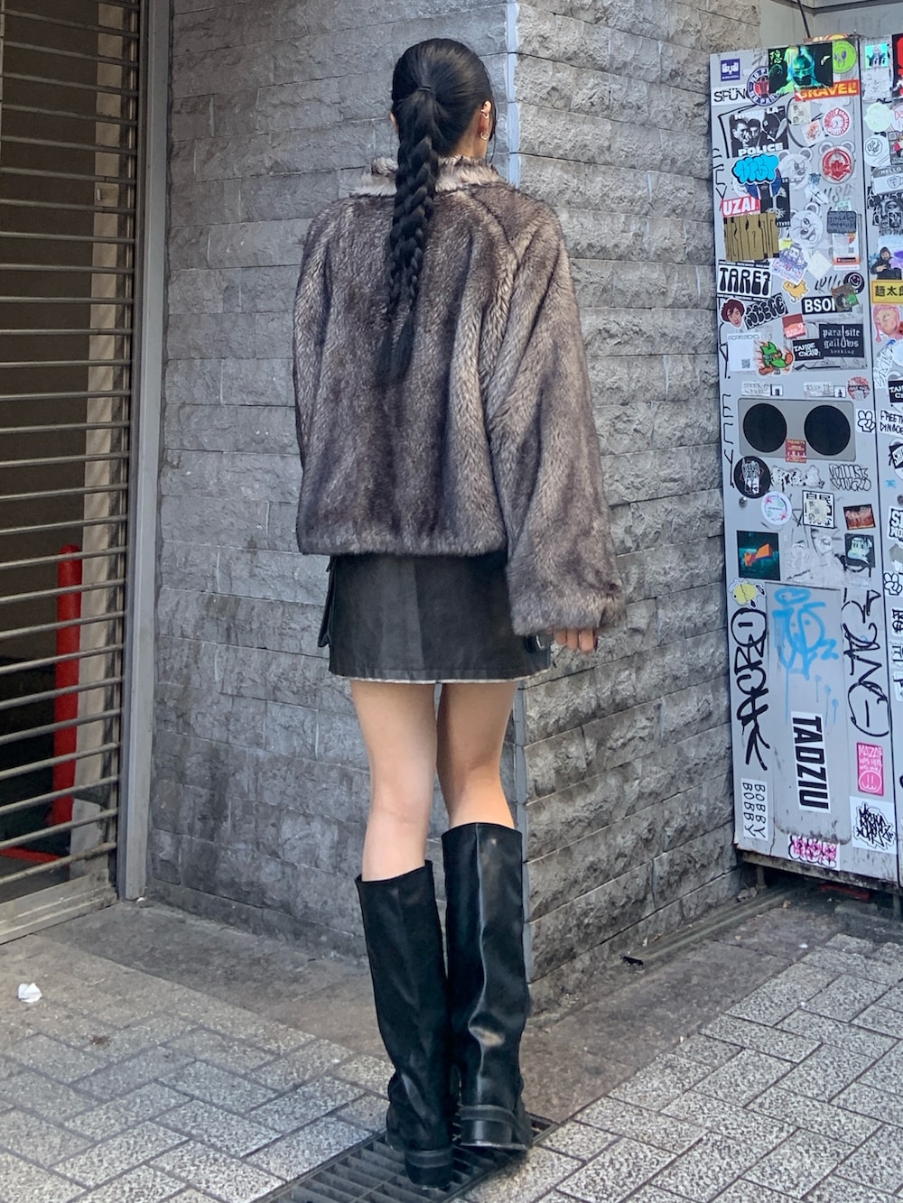 グレー系のブルゾン、ブラウン系のスカート、ブラック系のブーツを着用したレディースの冬コーディネートの4枚目の写真