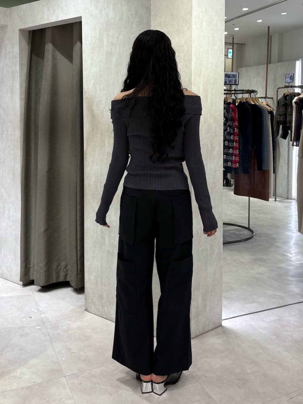 グレー系のニット/セーター、ブラック系のスラックス、ブラック系のパンプスを着用したレディースの春コーディネートの3枚目の写真