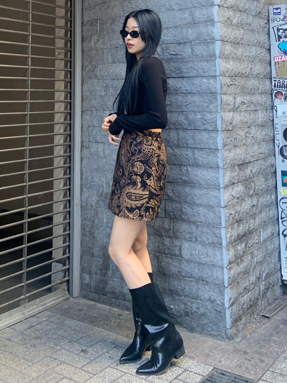 ブラック系のニット/セーター、ブラック系のスカート、ブラック系のブーツを着用したレディースの冬コーディネートの3枚目の写真